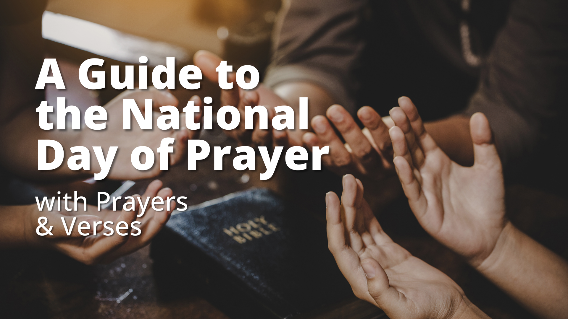 Hands praying around a Bible