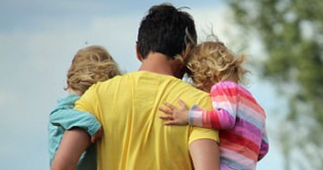 Dad carrying two little girls, backs to us