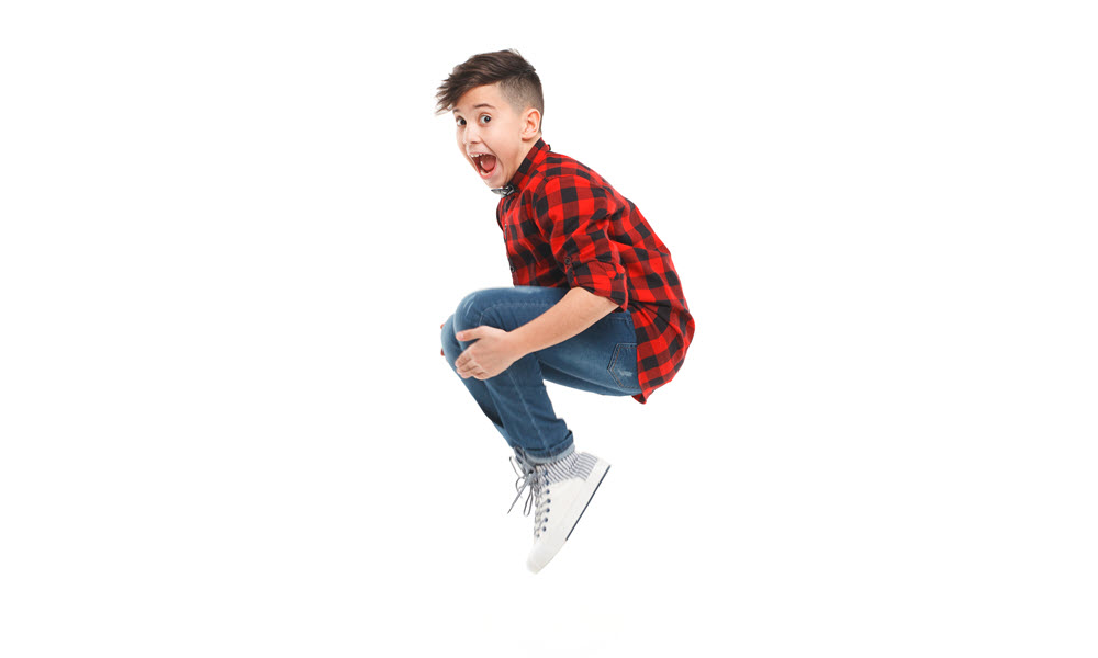 Little boy jumping and holding his knees