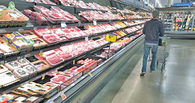 Man walking down meat aisle at grocery store