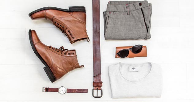 Boots, belt, watch pants, shirt and sunglasses arranged for picture