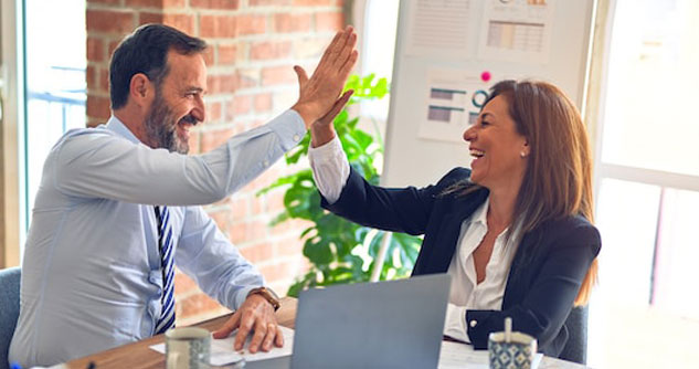 Man high-fives woman after discussing business plan