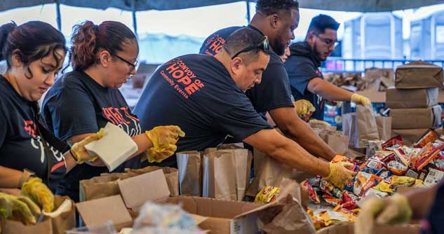 Convoy volunteers assemble food packs on site