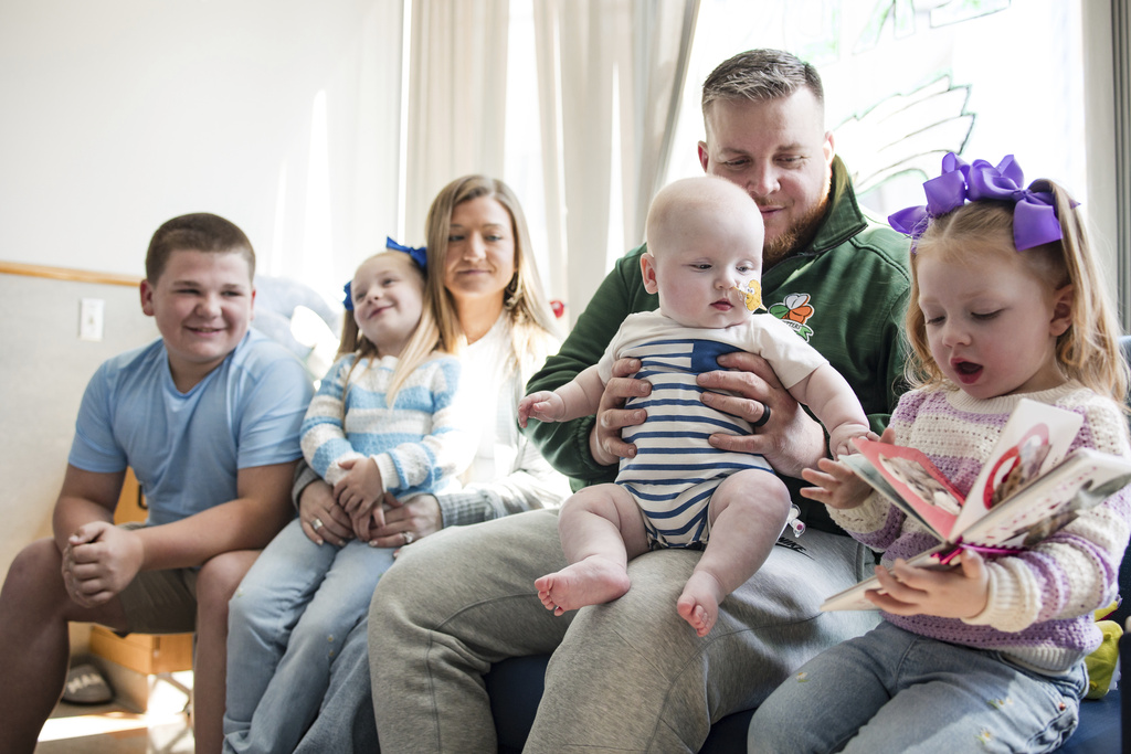 KJ Muldoon sits with his parents, Kyle and Nicole Muldoon, and his siblings after a follow up dose of an experimental gene editing treatment
