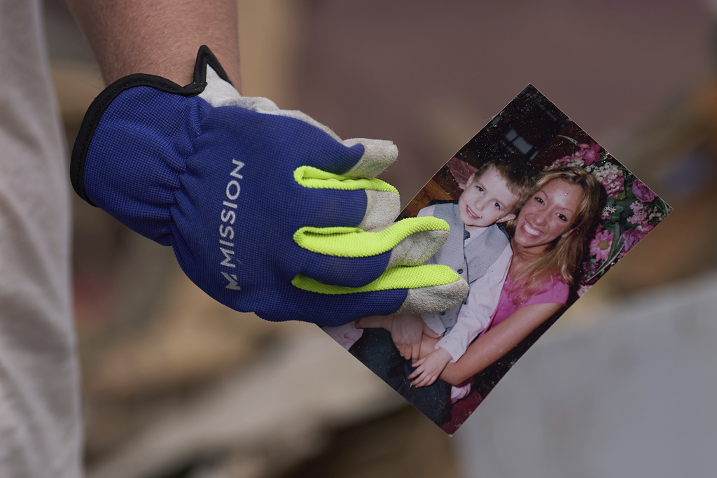 Edwina Wilson holds a photo she found in what is left of her destroyed home in London, Ky.