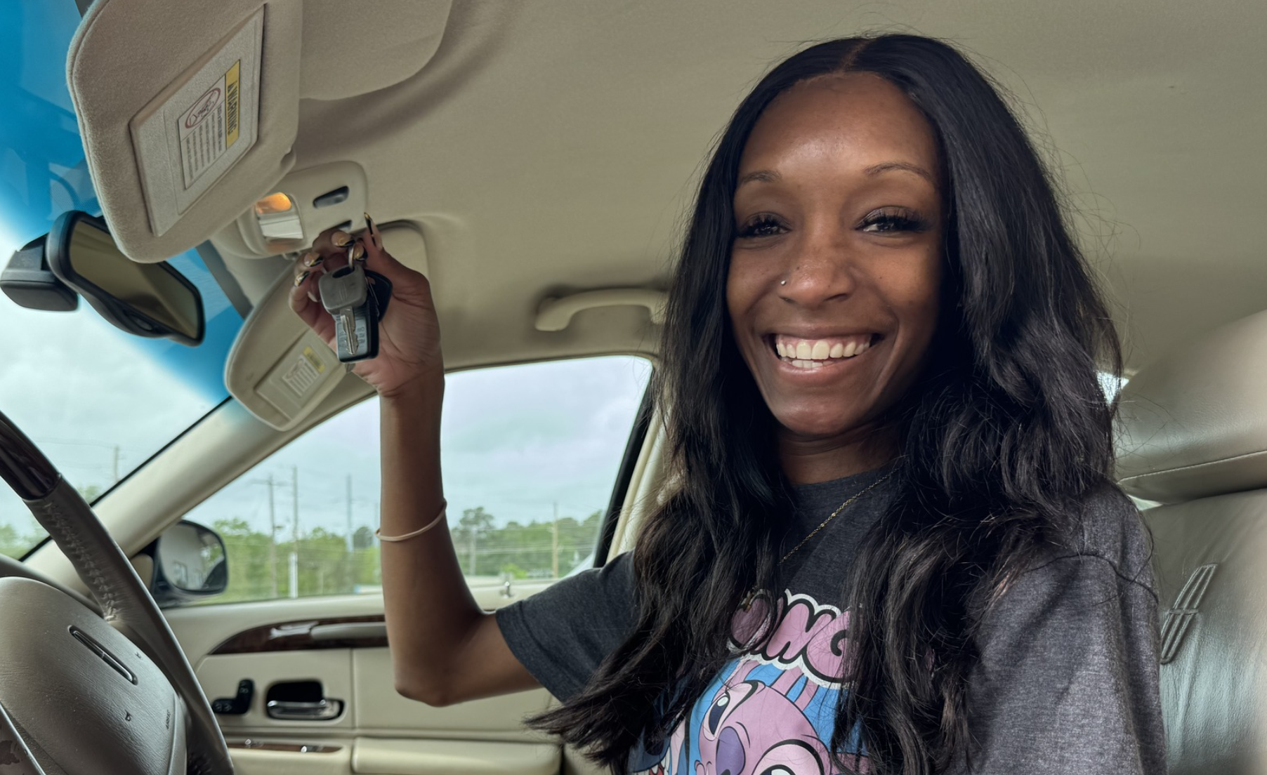 A woman holding car keys and smiling
