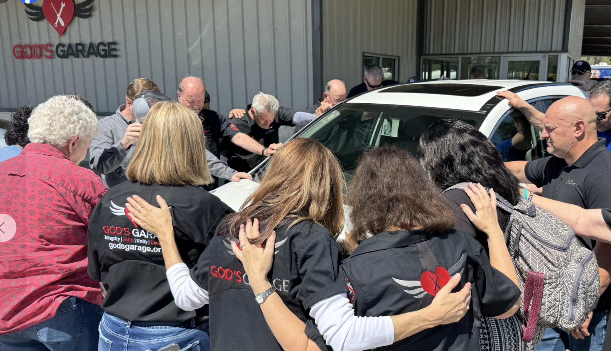 A car surrounded by praying people