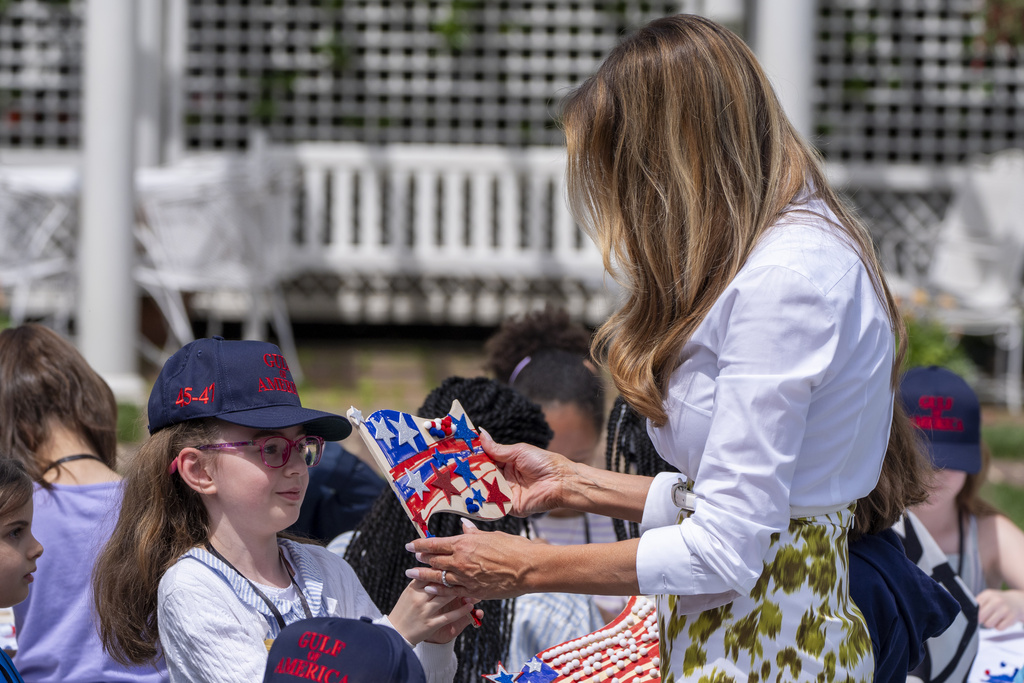 First lady Melania Trump looks at a decorated flag as she participates in flag decorating during a Take Our Child to Work Day event in the Jacqueline Kennedy Garden at the White House