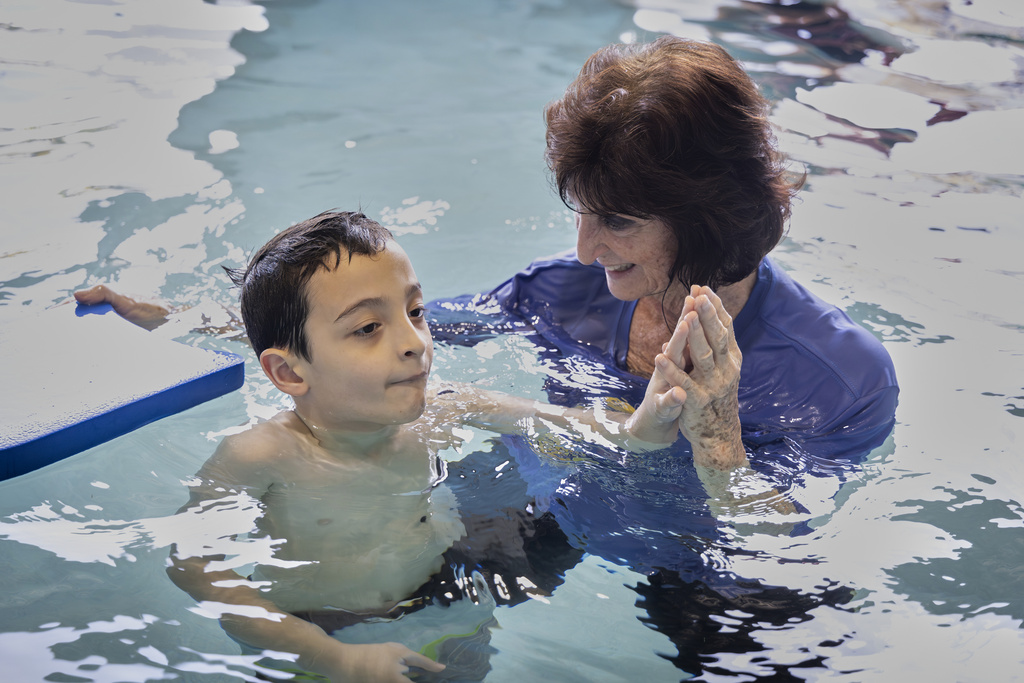 Instructor Dottie Diedrick guides a student in the water during an autism-specific swim class
