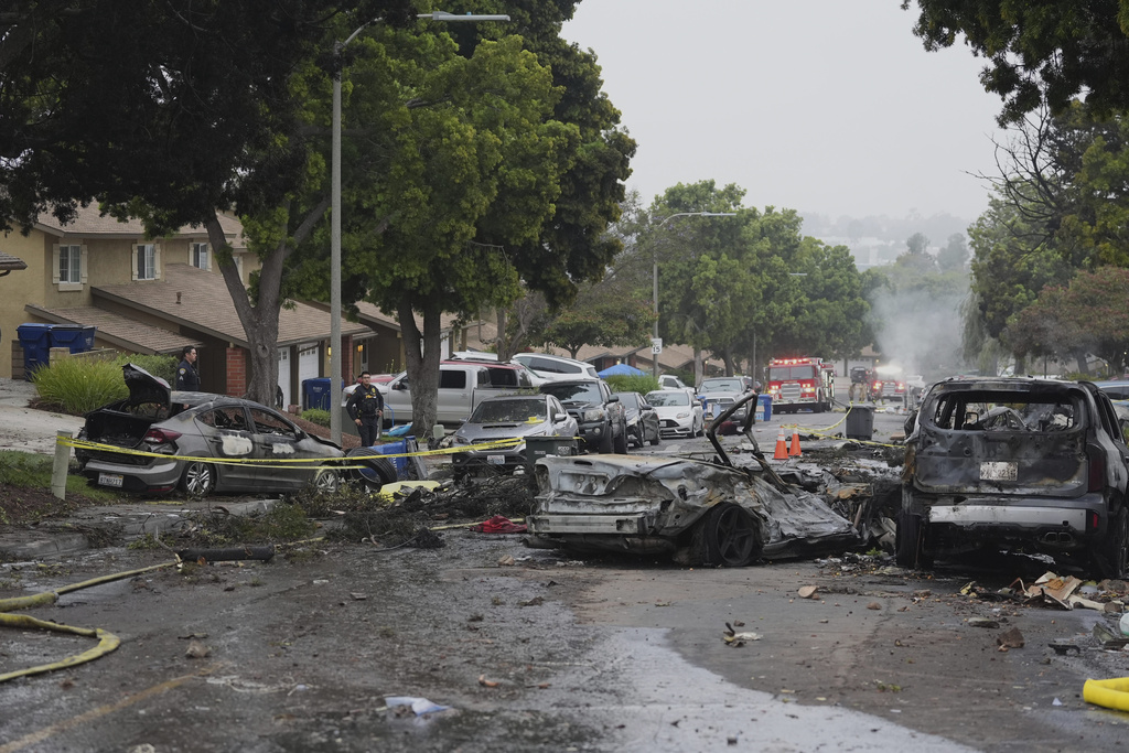 Authorities work the scene where a small plane crashed into a San Diego neighborhood