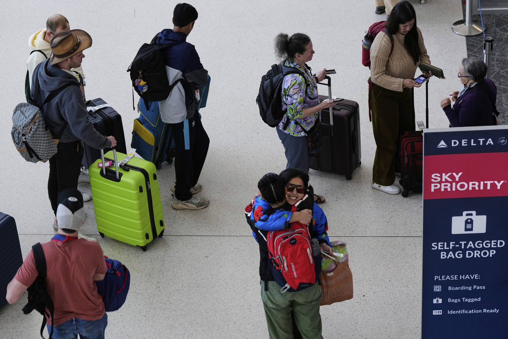 Travelers wait in line to check-in their luggage at San Francisco International Airport