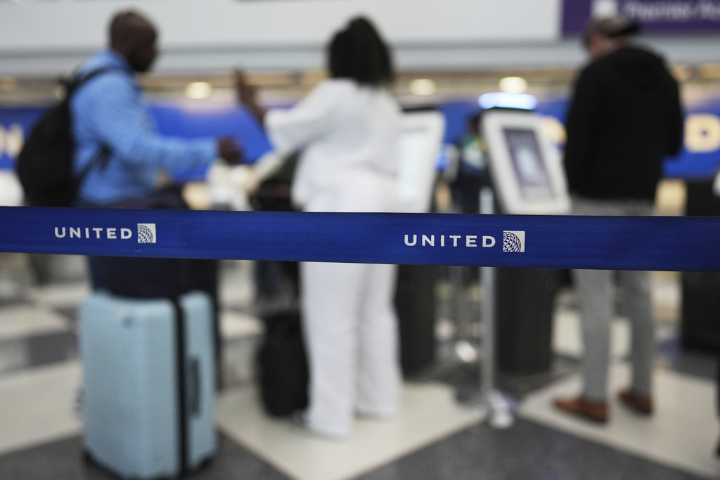 Travelers print out their boarding passes at kiosks inside of O