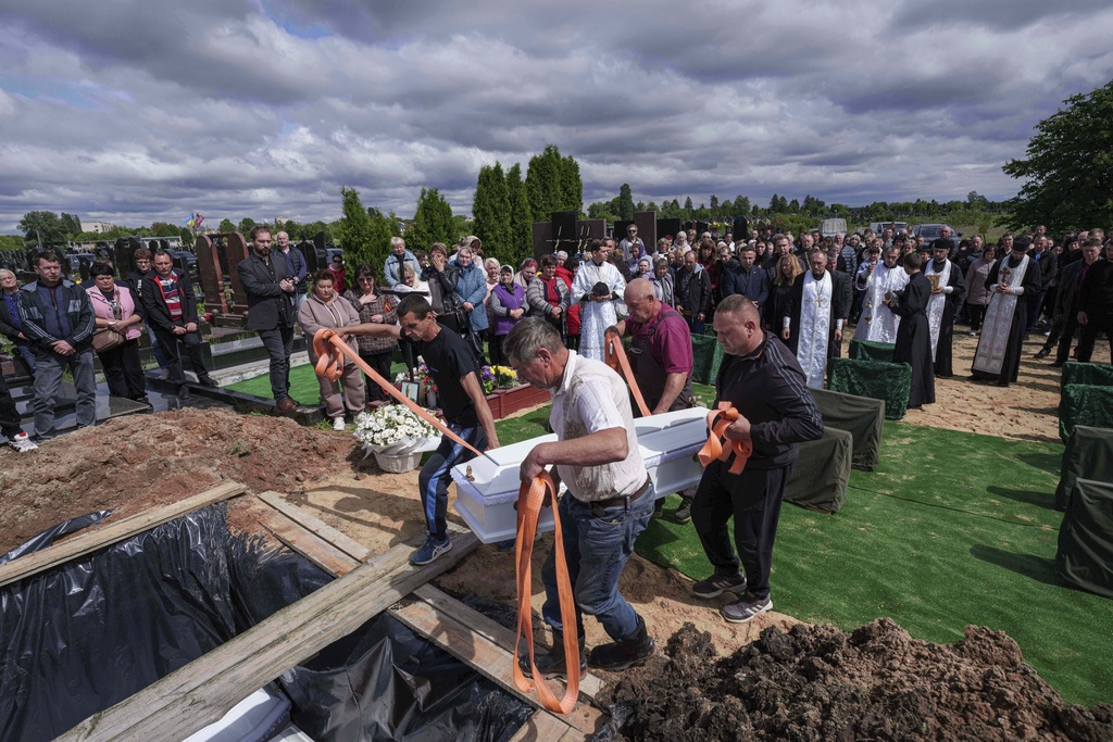 Funeral workers carry the coffin of Tamara Martyniuk, 8, killed in a Russian strike on Sunday together with Stanislav Martyniuk, 12, and Roman Martyniuk, 17, during a funeral ceremony in Korostyshiv, Zhytomyr region, Ukraine