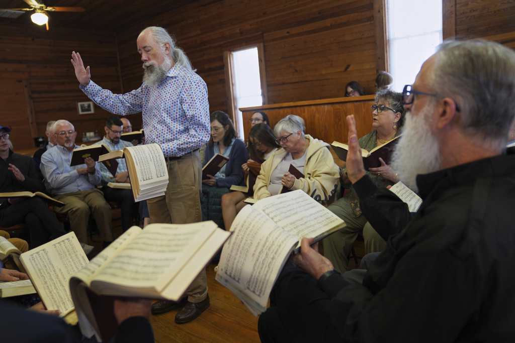 Andy Ditzler stands in the center of a hollow square, "The Sacred Harp" formation in which singers organize into four voice parts and face each other to create an opening in the middle