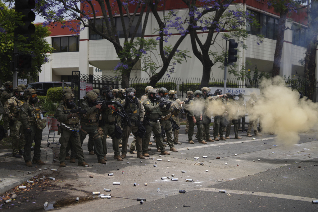 Border Patrol personnel deploy tear gas during a demonstration over the dozens detained in an operation by federal immigration authorities