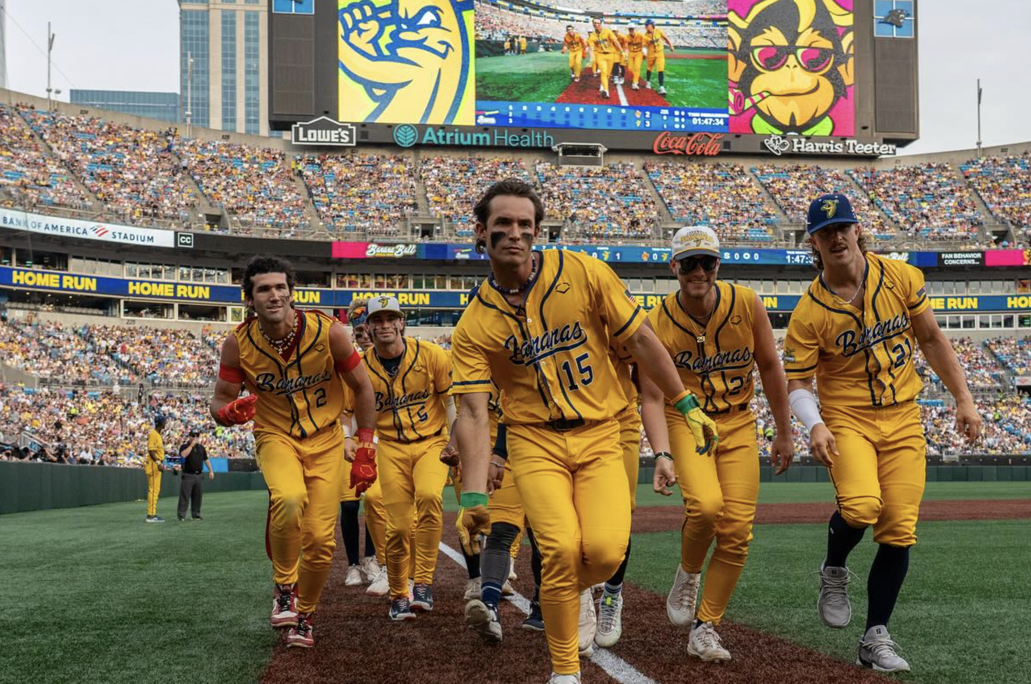 Men in yellow baseball uniforms dancing at a stadium