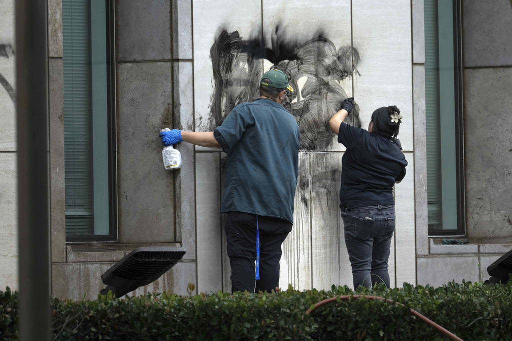 Workers remove graffiti from the Ronald Reagan Federal Building and Courthouse in Santa Ana