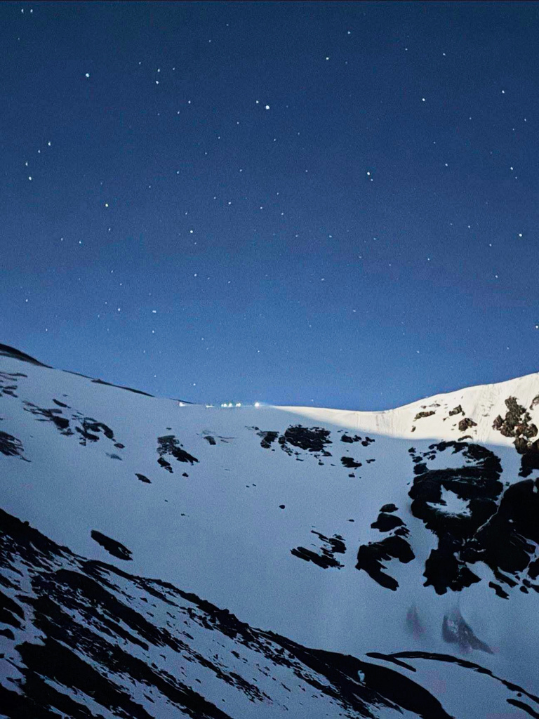 Lamps are illuminated on a ridge as Alpine Rescue Team members take part in helping get two men struck by lightning off Torreys Peak in Colorado