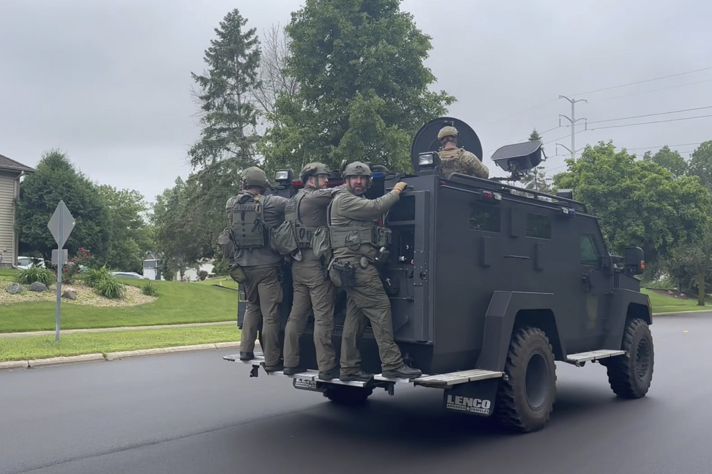 Police deploy as a manhunt is underway for a shooter that targeted two state lawmakers, in Brooklyn Park, Minn.