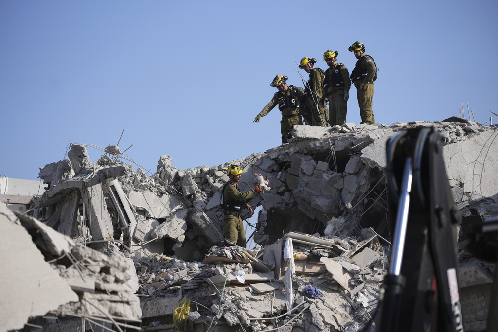 Israeli security forces inspect destroyed houses that were struck by a missile fired from Iran, in Rishon Lezion, Israel