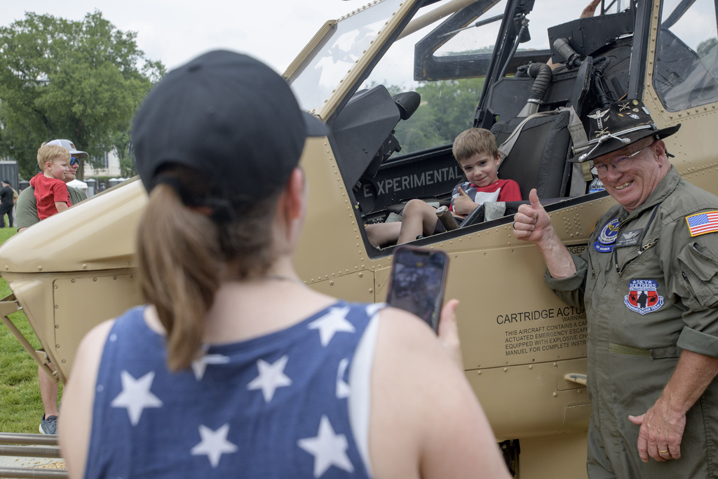 Retired Army CW4 Floyd Werner Jr., right, poses with Victor Koza, 5, center, as his mother, Melinda Koza, left, takes a photo in front of an AH-1F Cobra 998 helicopter during an event to honor the Army