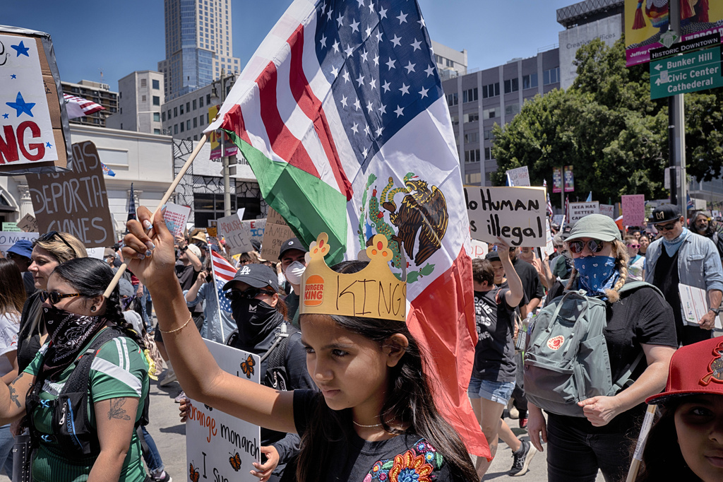 A young protester carries a combination Mexican and U.S. flag during a "No Kings" protest in downtown Los Angeles