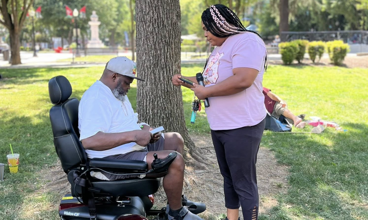 Woman shares Jesus with a man in a wheelchair
