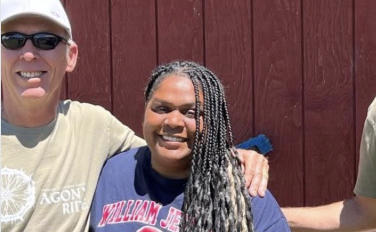 Jackie smiling with a man with sunglasses on