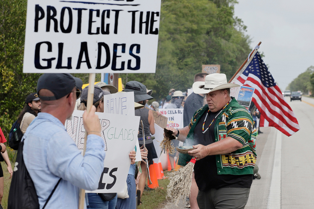 Gary Wilcox with the American Indian movement blesses and cleanses environmental advocates and protesters at the Dade-Collier Training and Transition Airport 