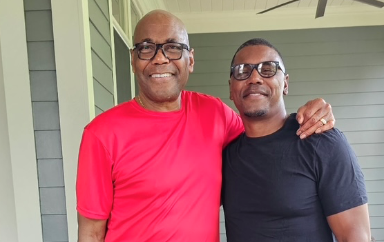 Father and son, smiling next to each other