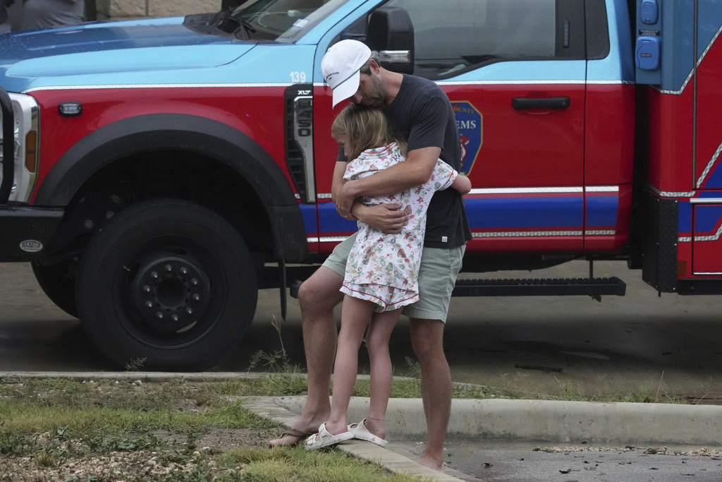 People are reunited at a reunification center after flash flooding hit the area, Friday, July 4, 2025, in Ingram, Texas.