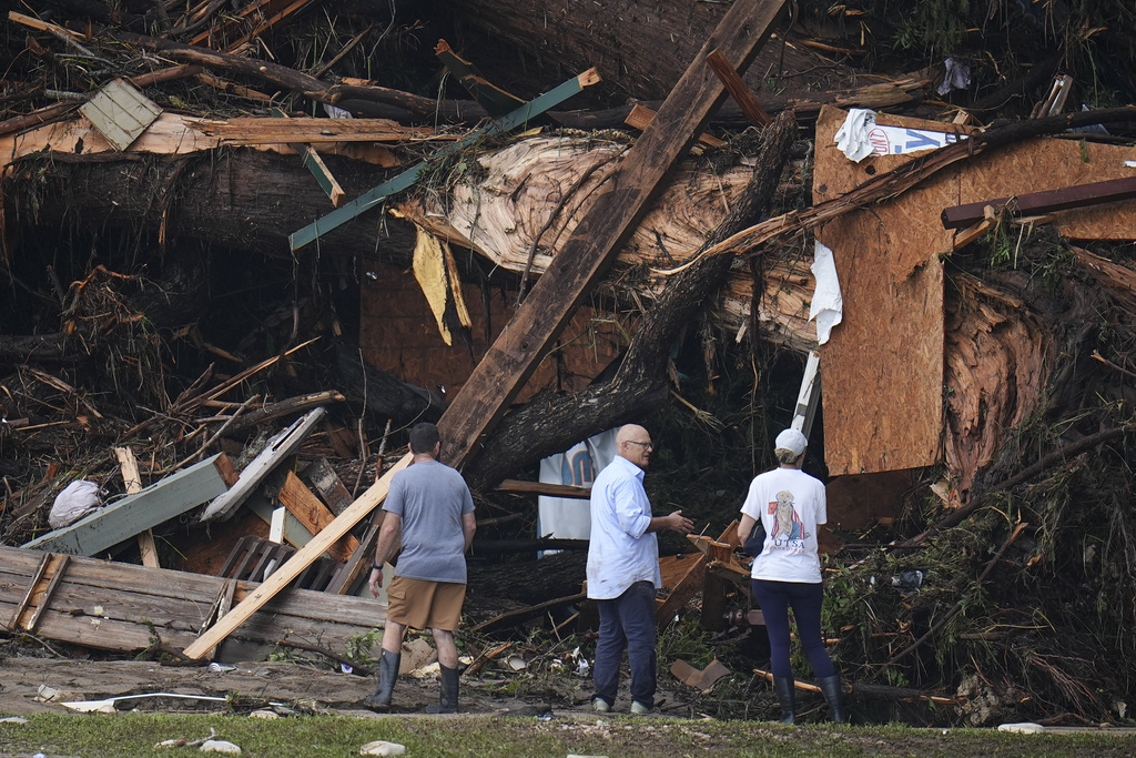 People look at debris on the banks of the Guadalupe River after a flash flood swept through the area Saturday, July 5, 2025, in Hunt, Texas.