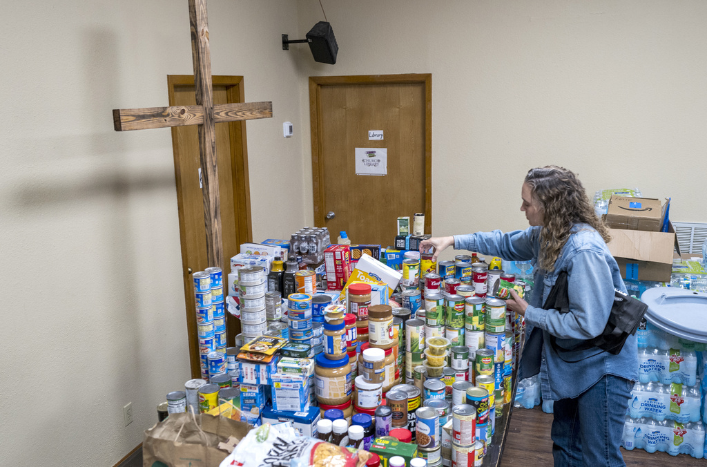 Lisa Reitz gets cans of food and other donations ready for distribution at the Hunt Baptist Church following extreme flooding along the Guadalupe River
