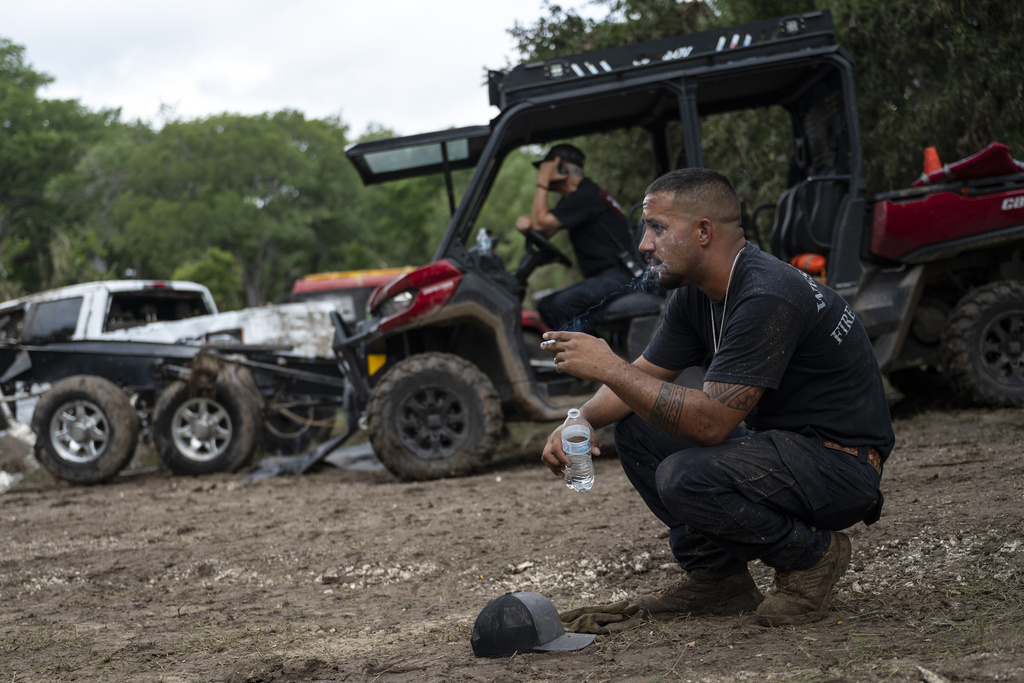 West Odessa Volunteer Firefighter Jed Wolske takes a smoke break while aiding in search and rescue efforts along the Guadalupe River, days after a flash flood swept through the area