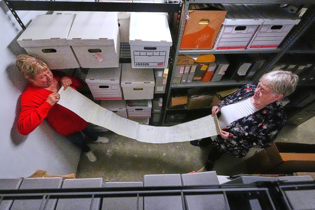 Historian Jennifer Cromack, left, and Rev. Diane Badger unfurl a recently found, 178-year-old anti-slavery scroll which was found in a storage box at Grotonwood, the home mission of The American Baptist Churches of Massachusetts