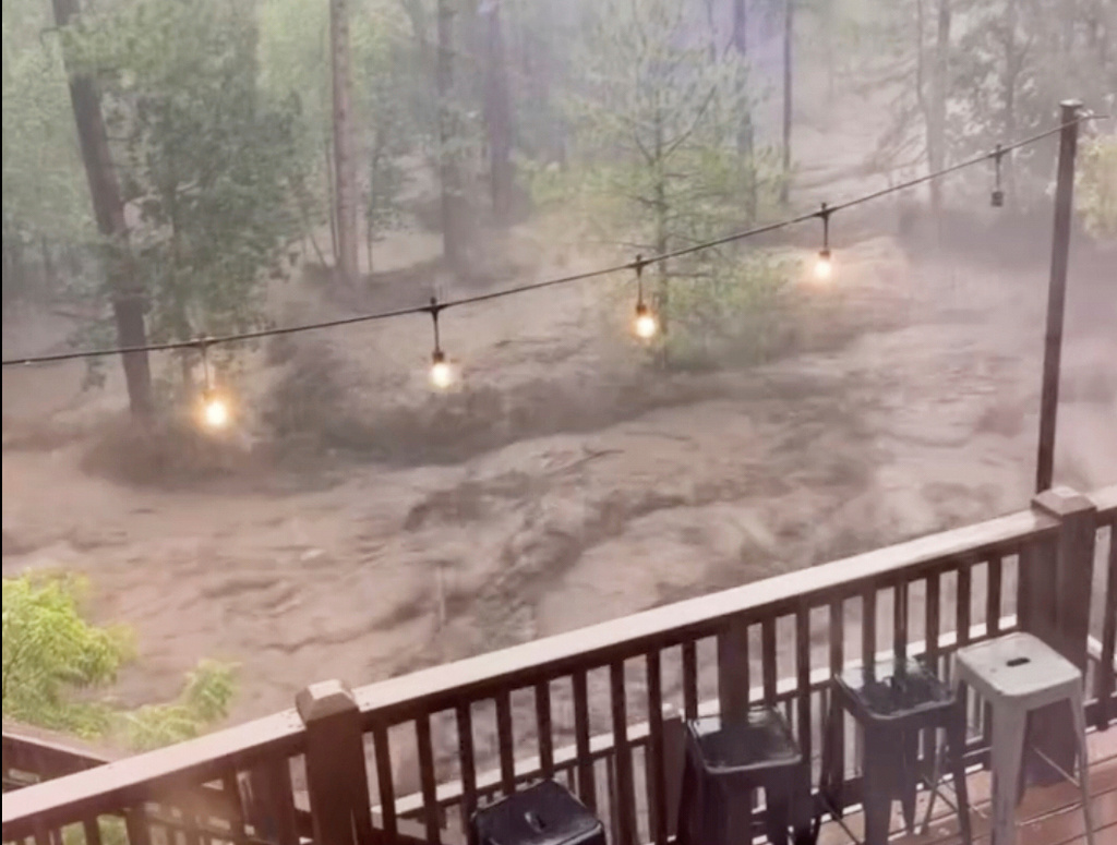 Flash flooding is seen behind a house in Ruidoso, N.M.