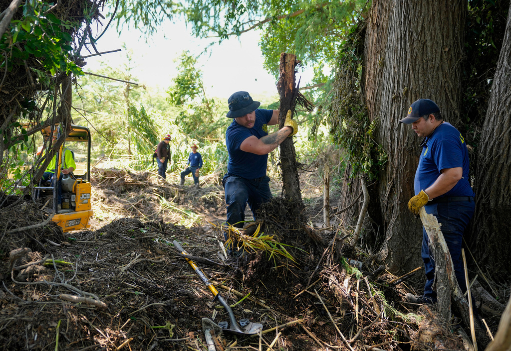 La Salle County Fire Rescue firefighters do search work on the banks of the Guadalupe River in Ingram, Texas