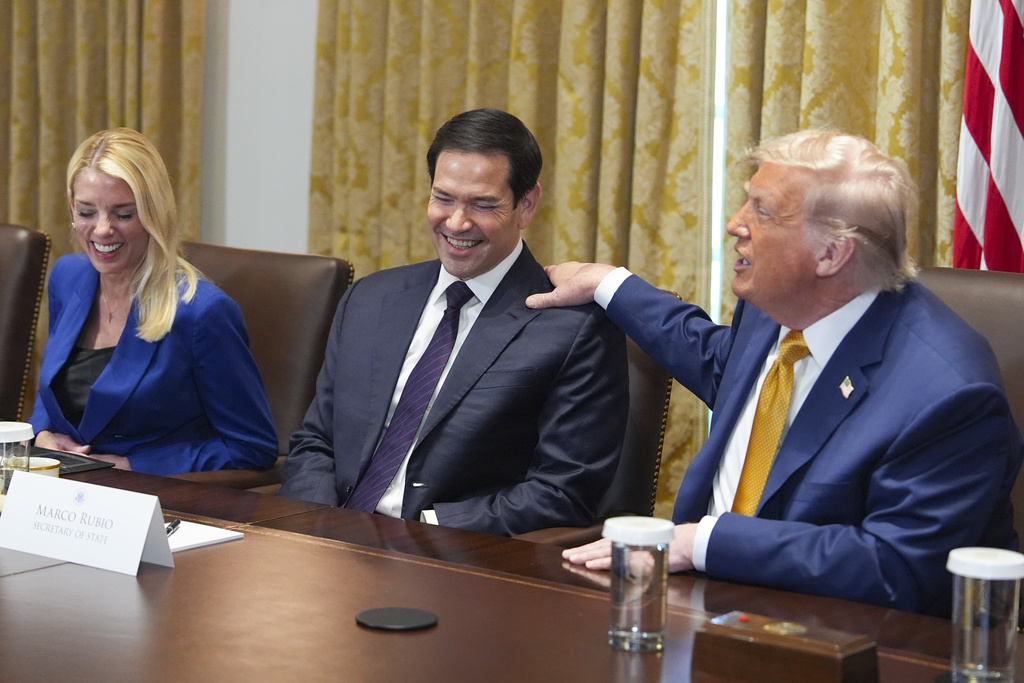 President Donald Trump, right, puts his hand on shoulder of Secretary of State Marco Rubio, center, as Attorney General Pam Bondi, left, looks on during a cabinet meeting at the White House