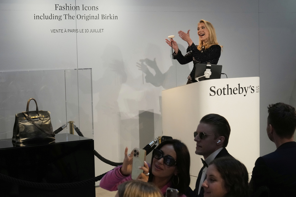 Auction officer Aurélie Vandevoorde gestures as the original Birkin bag created by Hermès for Jane Birkin was sold at auction