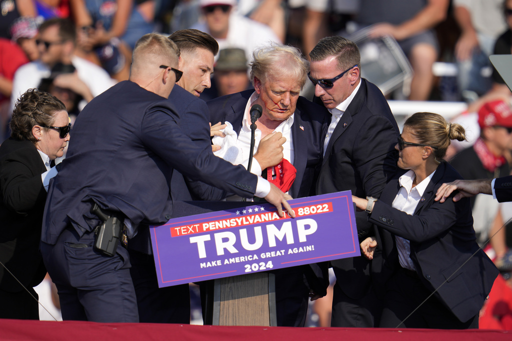 Republican presidential candidate former President Donald Trump is helped off the stage
