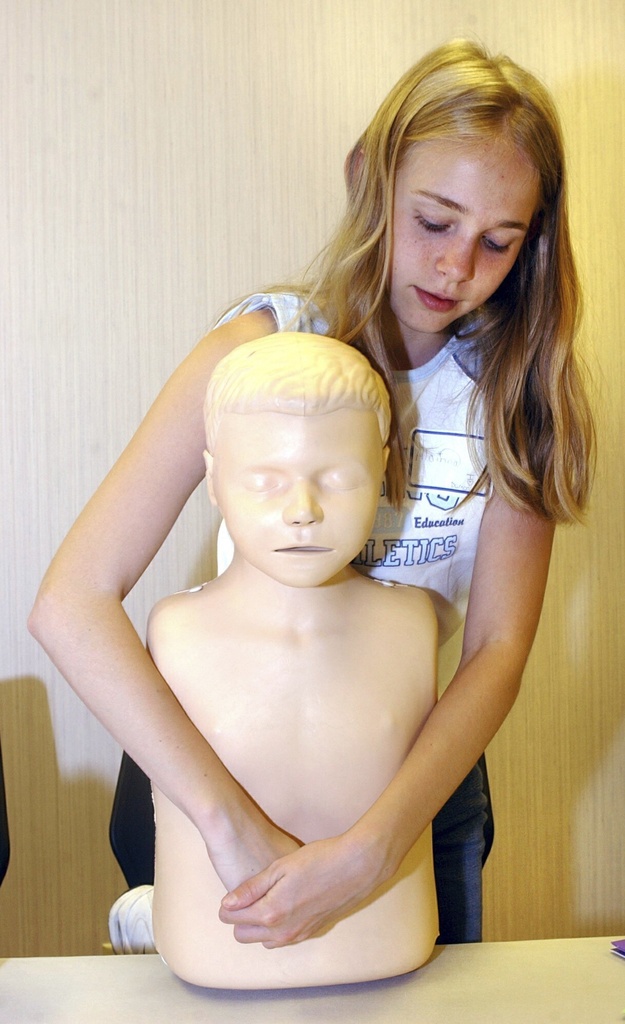 Alainna Lantz, 12, of Bridgeport, W.Va., practices the Heimlich maneuver during a free Safe Sitter course offered by West Virginia University