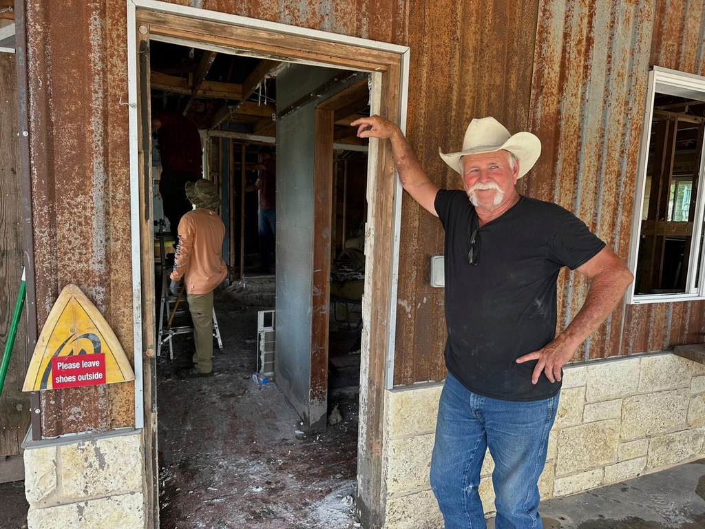 Volunteer Dave Calame stands outside a home he is helping clean after flooding in Comfort, Texas