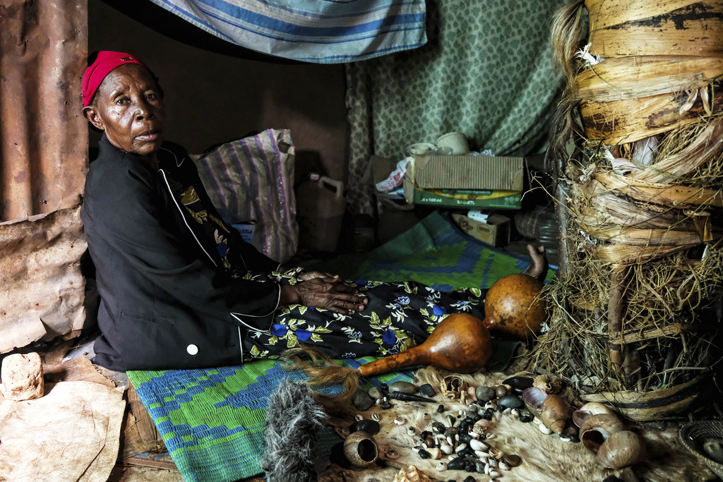 Traditional healer Rose Mukite poses for a photograph inside her igloo-shaped shrine