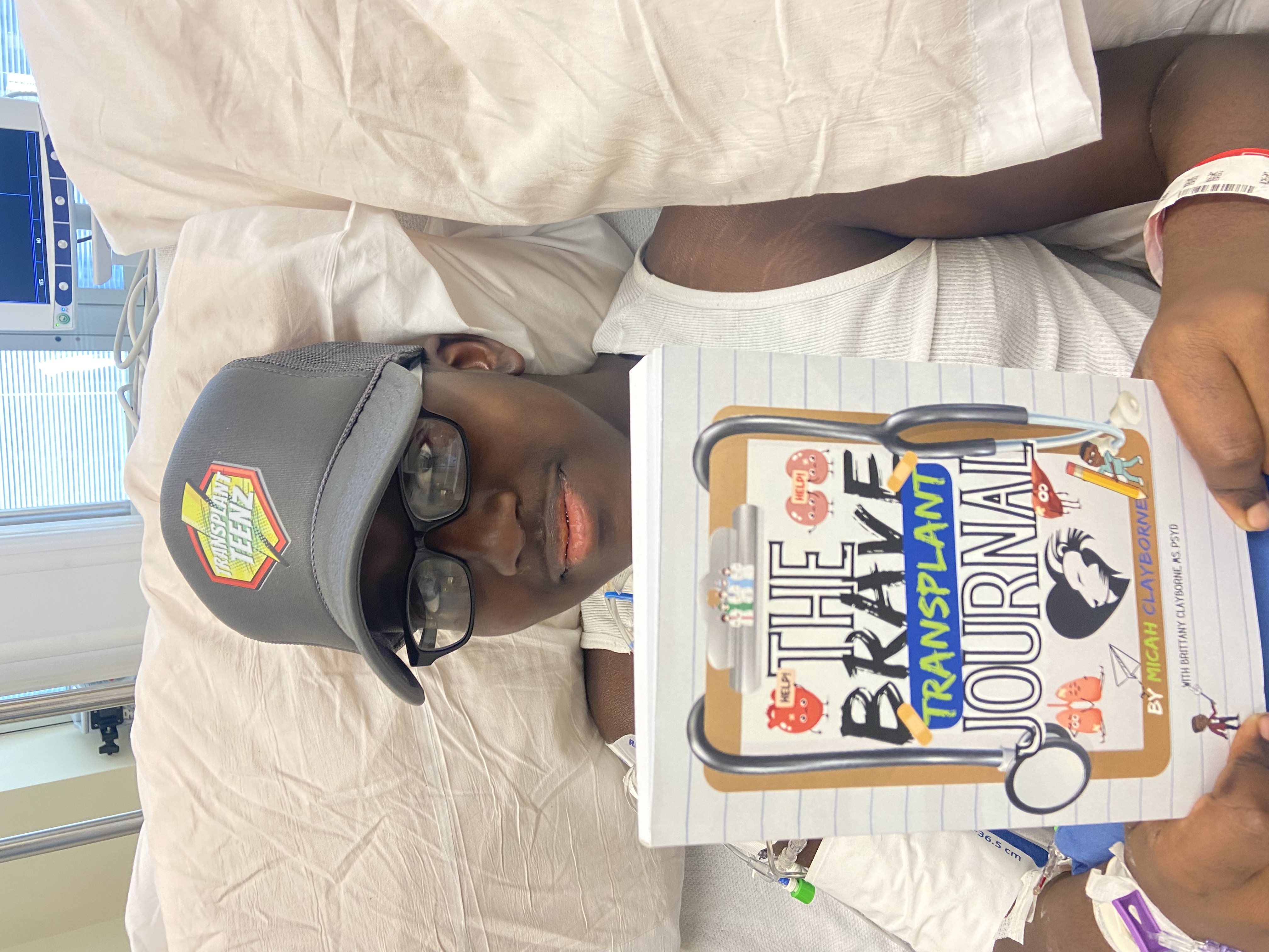 Young teenage boy with a Transplant Teenz hat and brave transplant journal in hand