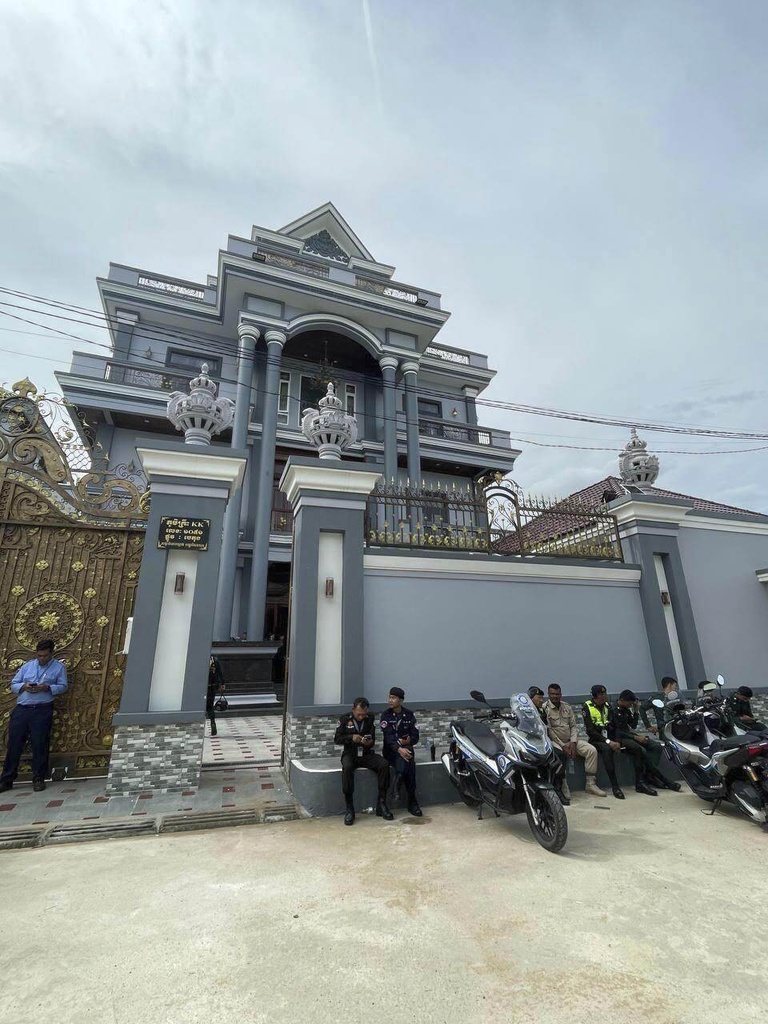 Police stand in front a villa that served as an alleged cyberscam center on the outskirts of the capital Phnom Penh, Cambodia
