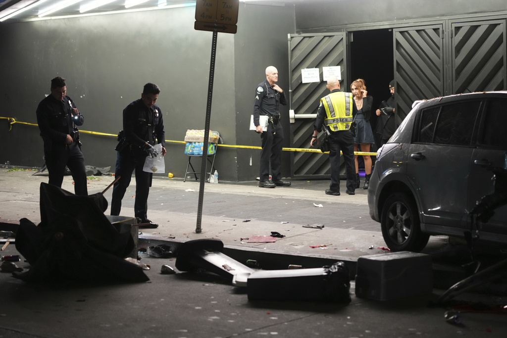 Law enforcement investigate the scene where a vehicle rammed into a crowd of people waiting to enter a nightclub along a busy boulevard in Los Angeles early Saturday