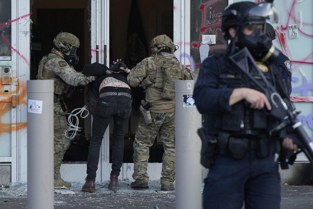 U.S. Customs and Border Protection agents detain a man outside the U.S. Immigration and Customs building during a protest in Portland, Ore.