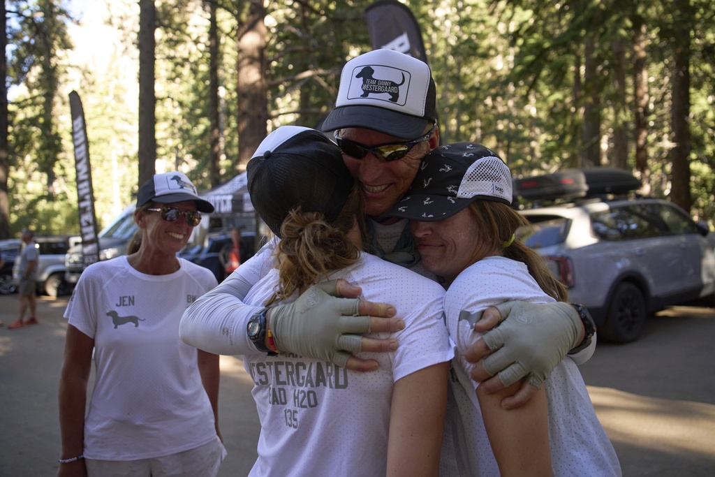 Danny Westergaard, second from right, embraces daughters Meagan Westergaard, right, and Madison Westergaard after finishing the Badwater 135 Ultramarathon