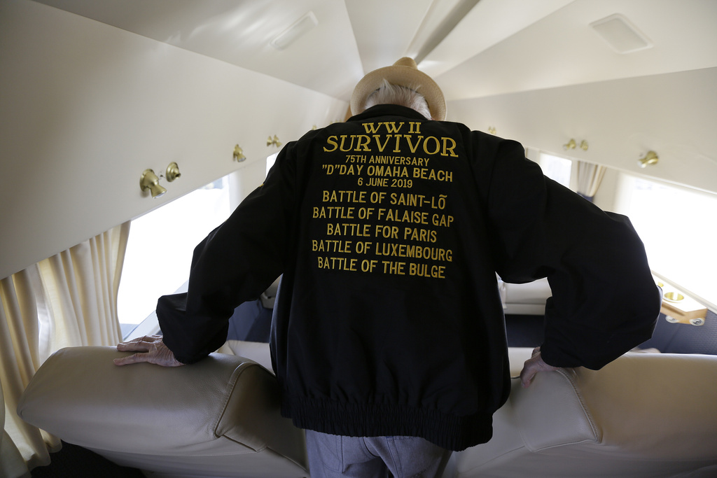 In this photo taken April 29, 2019, D-Day veteran Jake Larson walks to a seat before going for a ride in the "The Spirit of Benovia" WWII-era aircraft in Oakland, Calif.