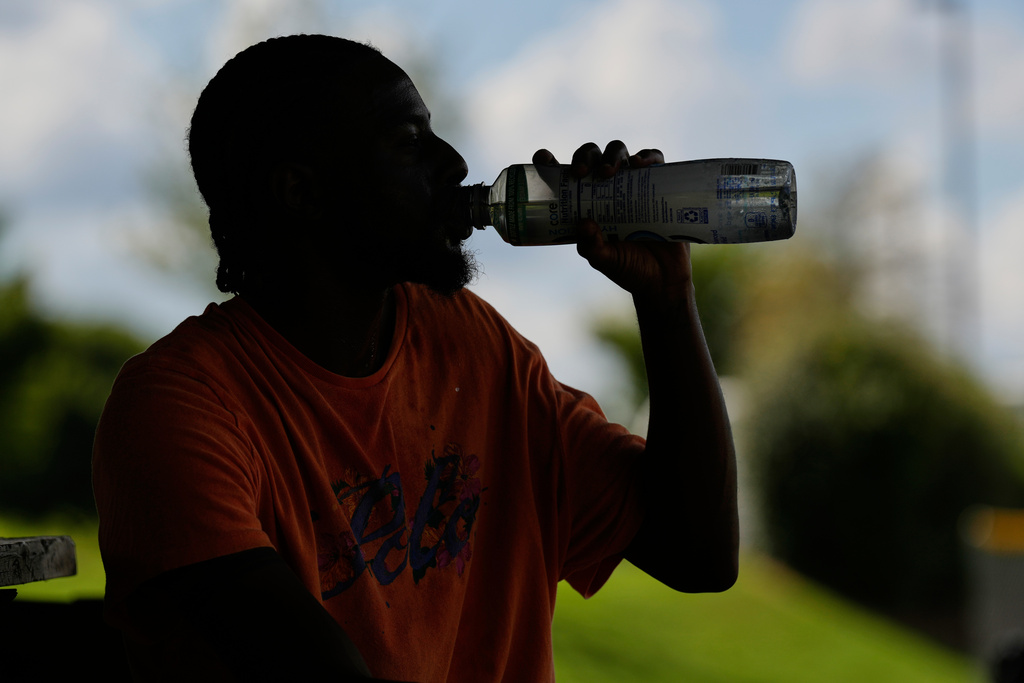 Marqui Scruggs takes a drink after playing basketball during a heat advisory in Murfreesboro, Tenn.